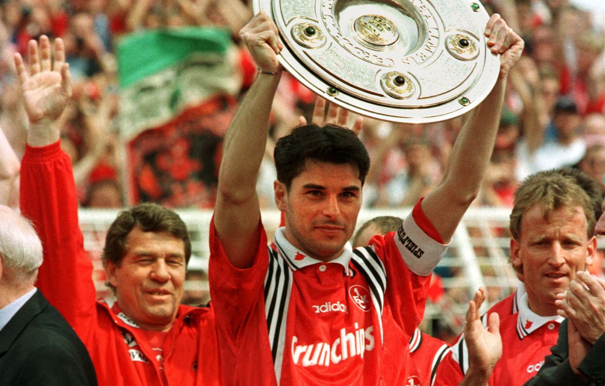 Team captain of German soccer champion Kaiserslautern, Ciriaco Sforza, displays the trophy in Hamburg's Volkspark Stadium on Saturday May 9, 1998, prior to the season's last match Hamburg vs ...