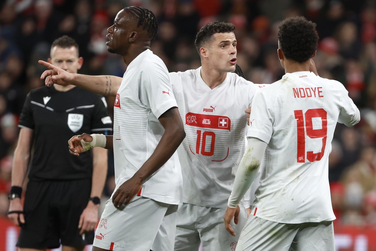 Switzerland's Granit Xhaka, center, talks to treammates Dan Ndoye and Denis Zakaria during the friendly soccer match between Denmark and Switzerland at the Parken stadium in Copenhagen, Denmark,  ...