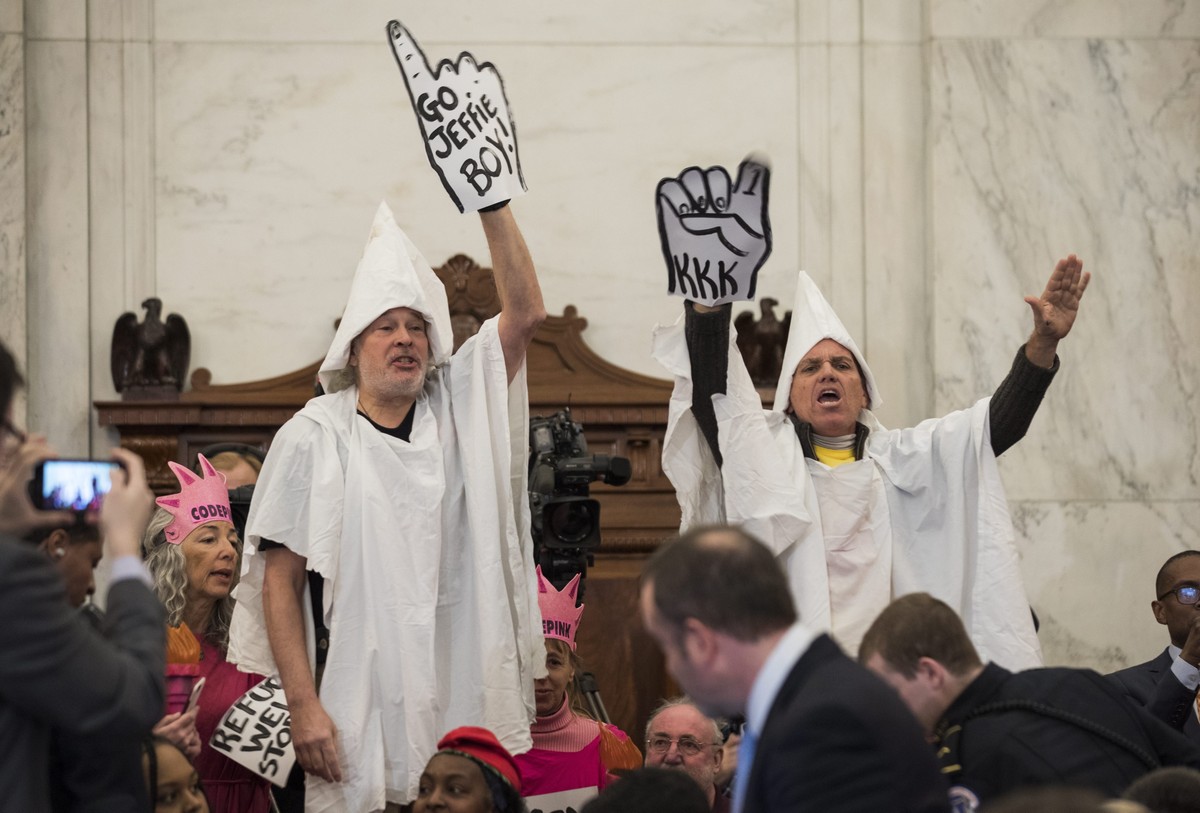 epa05709479 Protesters with the activist group 'CodePink' dressed as Klan members protest Republican Senator from Alabama Jeff Sessions before he testified at his confirmation hearing to be  ...