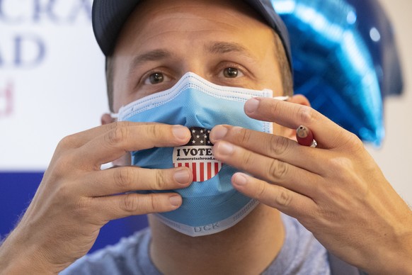 Elliott Zaagman from Michigan put a voting sticker on his mask after casting his vote on Super Tuesday, for U.S. Democrats Abroad multi-location global primary at Foreign Correspondents&#039; Club of  ...