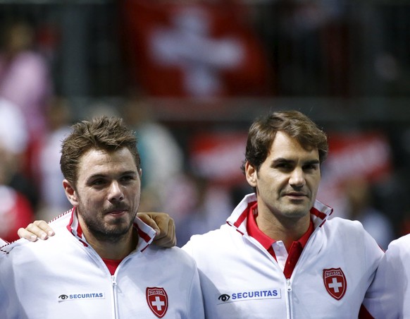 Switzerland&#039;s Stan Wawrinka (L) and Roger Federer sing the national anthem before their Davis Cup World Group play-off tennis match against the Netherlands at the Palexpo Arena in Geneva Septembe ...