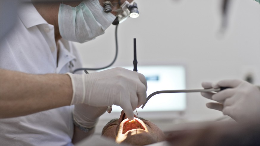 Dentist Martin von Ziegler inspects a patient&#039;s teeth with a mirror and probe in his dental practice in Zurich, Switzerland, pictured on April 6, 2010. (KEYSTONE/Gaetan Bally)

Zahnarzt Martin vo ...