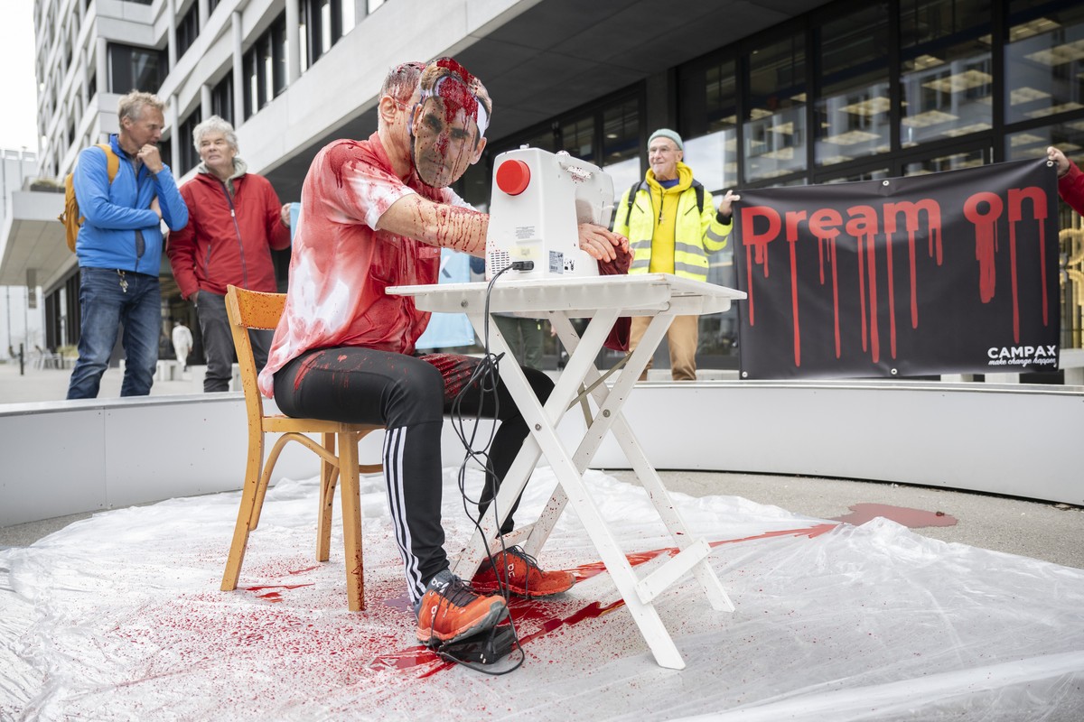 A man dressed as Roger Federer sits at the sewing machine, a campaign by Campax, a Swiss citizens' movement, in the front of the On flagship store in Zurich, Switzerland, Wednesday, 14 February 2 ...