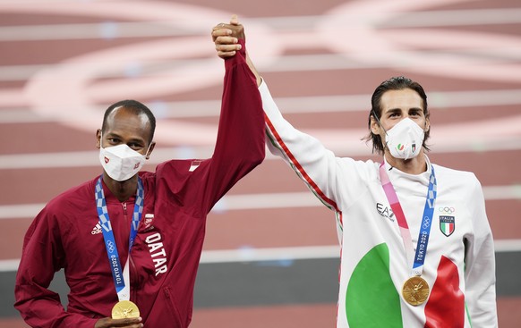 epa09387668 Joint gold medalists Mutaz Essa Barshim (L) of Qatar and Gianmarco Tamberi of Italy during the medal ceremony for the Men&#039;s High Jump at the Athletics events of the Tokyo 2020 Olympic ...