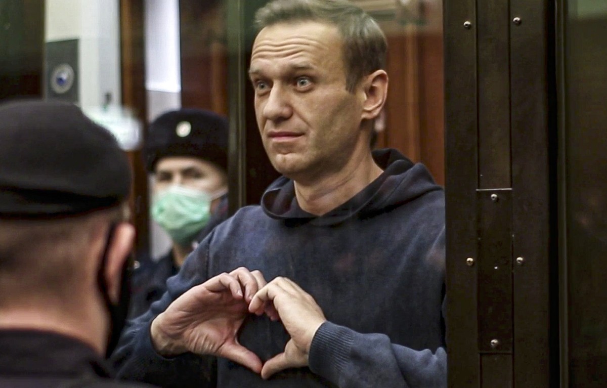 FILE - In this handout photo taken from video provided by the Moscow City Court on Feb. 2, 2021, Russian opposition leader Alexei Navalny shows a heart symbol while standing in a cage for defendants i ...