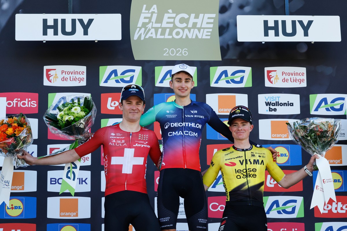 Paul Seixas of France celebrates on the podium after winning the Belgian cycling classic Fleche Wallonne (Walloon Arrow), ahead of second placed Mauro Schmid of Switzerland, left, and third placed Ben ...