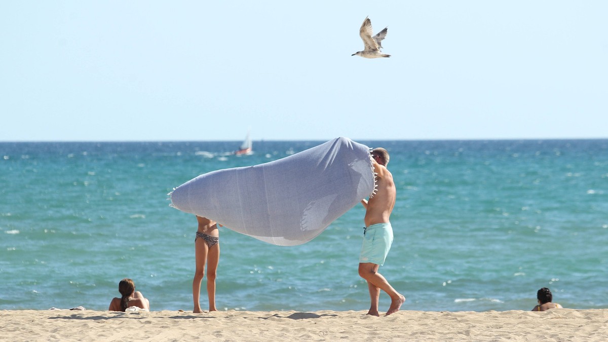 Ein Mann und eine Frau stehen bei Temperaturen über 35 Grad am Strand von Playa de Palma. Mallorca Spanien *** A man and a woman stand on the beach of Playa de Palma Mallorca Spain in temperatures abo ...