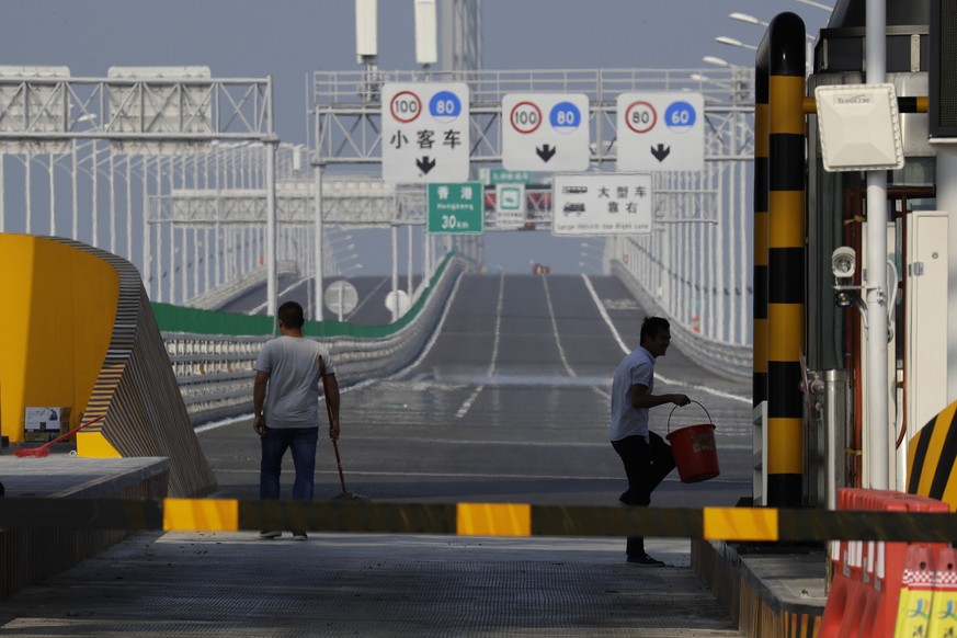 Workers clean the surface on the Hong Kong-Zhuhai-Macau Bridge, in Zhuhai city, south China&#039;s Guangdong province, Wednesday, March 28, 2018. The Hong Kong-Zhuhai-Macau Bridge, the world&#039;s lo ...