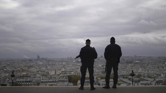 FILE - In this Oct. 30, 2020, file photo, police officers stand guard next to the Sacre Coeur basilica in Paris, following an attack at a church in the Mediterranean city of Nice. Scrubbing France cle ...