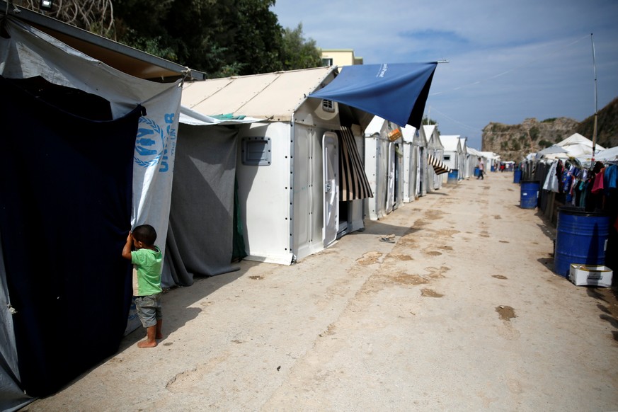 A boy looks inside a tent at the Souda municipality-run camp for refugees and migrants on the island of Chios, Greece, September 6, 2016. REUTERS/Alkis Konstantinidis