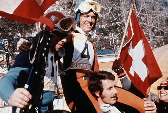 Der Schweizer Abfahrts-Olympiasieger Bernhard Russi (Nr. 4) und der Schweizer Olympiazweite Roland Collombin (Nr. 11) auf den Schultern der Fans an den Olympischen Winterspielen in Sapporo 1972. Die & ...