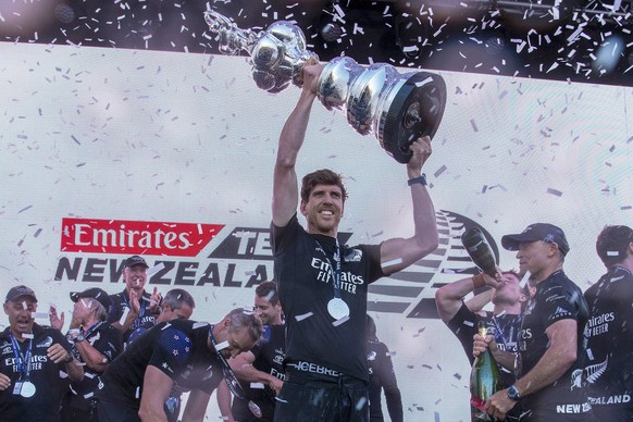 FILE - Emirates Team New Zealand helmsman Peter Burling holds the America's Cup trophy aloft after defeating Italy's Luna Rossa in race 10 of the America's Cup on Auckland's Waitem ...