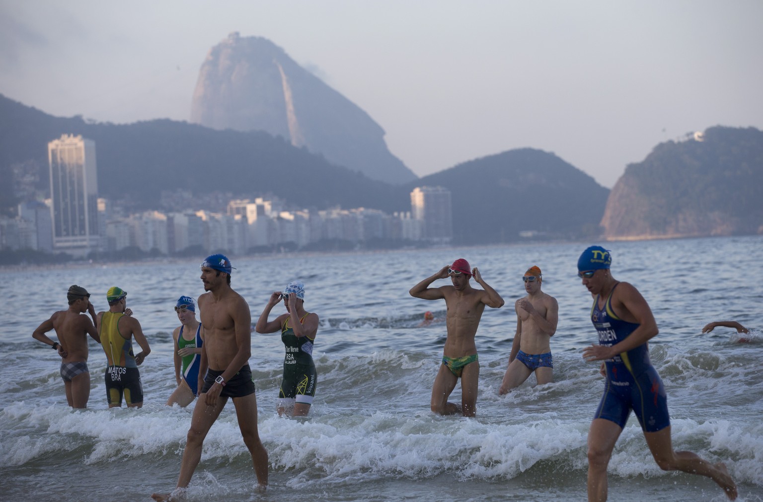 Triathleten steigen aus dem Wasser an der Copacabana, wo demnächst die olympischen Qualifikationen beginnen. (AP Photo/Silvia Izquierdo)