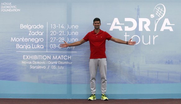 Djokovic posiert stolz vor dem Kalender seiner Adria Tour.