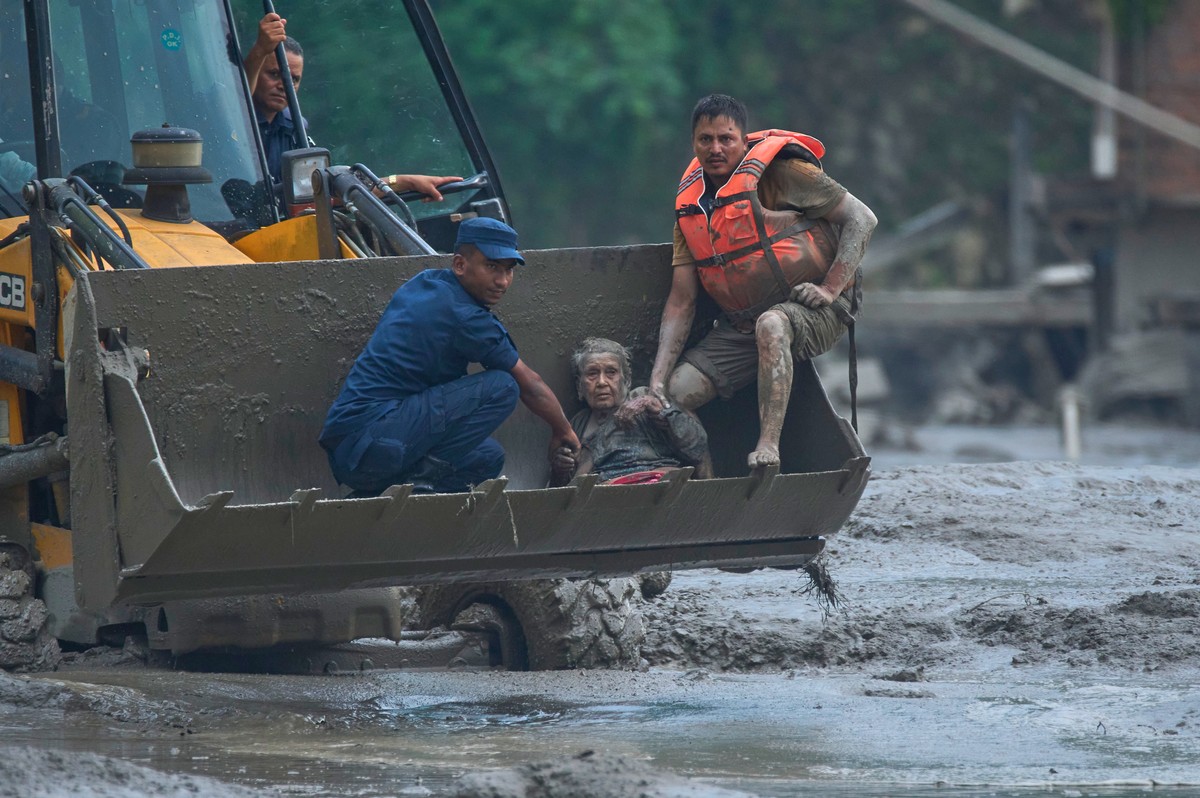 KEYPIX - Rescuers use an earthmover to carry a victim of flash flooding to safety along the Trishuli River in Nepal's Nuwakot district, Wednesday, Aug. 26, 2026. (AP Photo/Niranjan Shrestha)