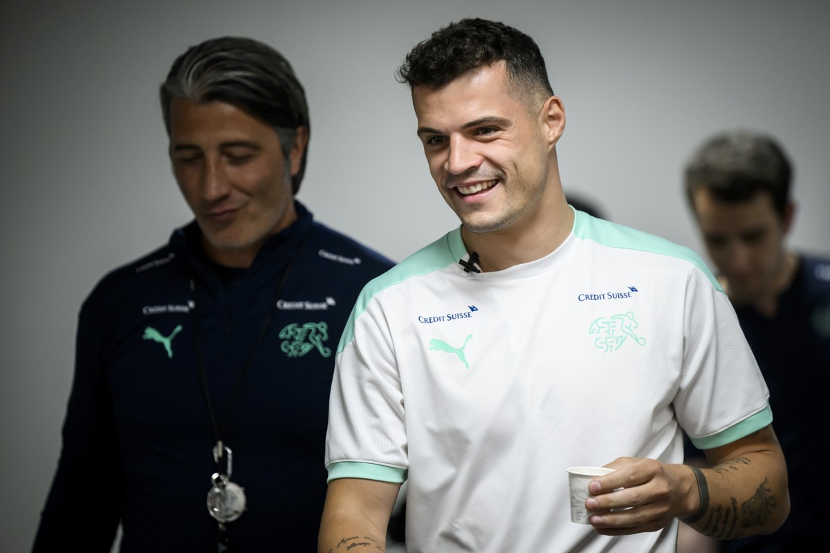 Switzerland's midfielder Granit Xhaka, right, arrives next to Switzerland's head coach Murat Yakin, left, during a a press conference on the eve of the UEFA Nations League group A2 soccer ma ...