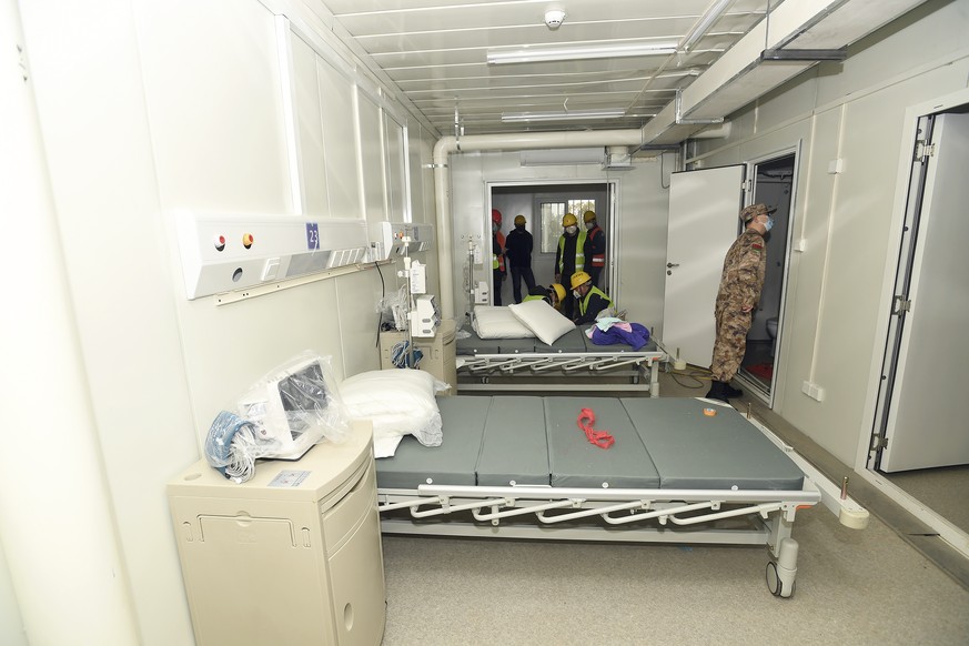 A Chinese army medic looks at a patient room at the Huoshenshan temporary field hospital in Wuhan in central China's Hubei Province, Sunday, Feb. 2, 2020. The Philippines on Sunday reported the f ...