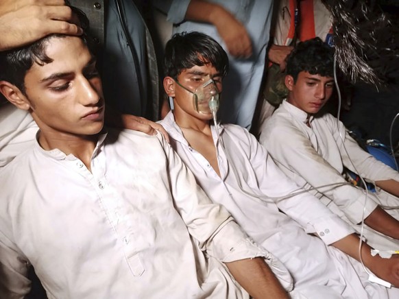 Youngsters, left, who were trapped in a broken cable car, receive first aid following their rescue, in Pashto village, a mountainous area of Battagram district in Pakistan&#039;s Khyber Pakhtunkhwa pr ...