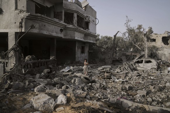 ein Mädchen vor einem zerstöreten Haus in Gaza