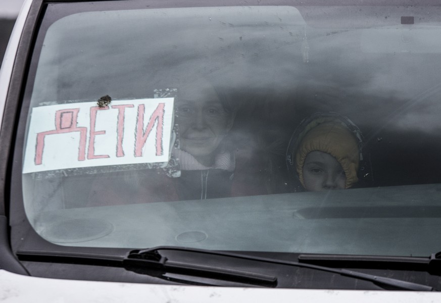 epa09806187 Mother and her son sit in a car with sign reading &#039;Children&#039; as they try to evacuate in the Irpin city near from Kyiv (Kiev), Ukraine, 06 March 2022. Russian troops began a milit ...
