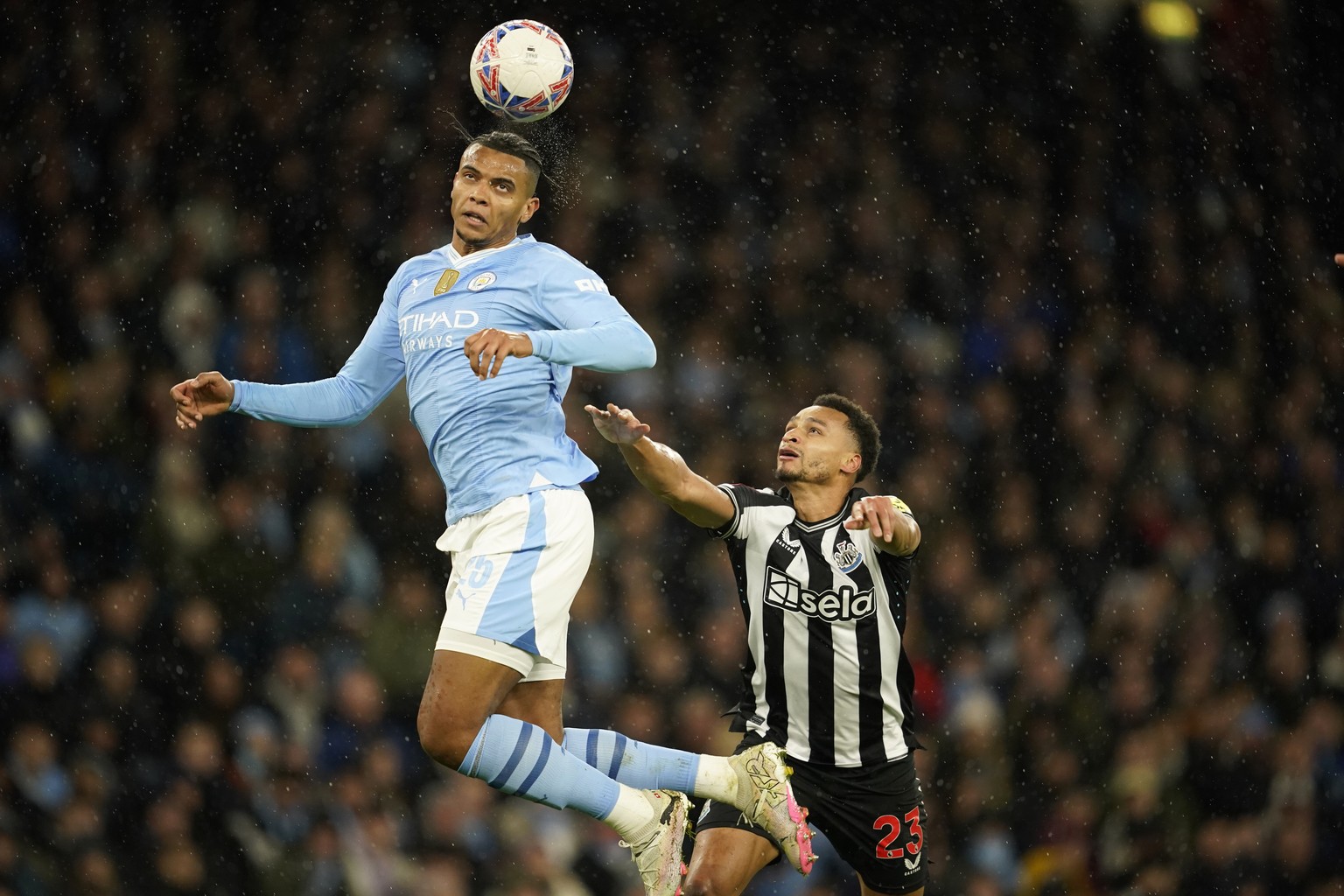 Manchester City&#039;s Manuel Akanji, top, jumps for the ball with Newcastle&#039;s Jacob Murphy during the FA Cup quarterfinal soccer match between Manchester City and Newcastle at the Etihad Stadium ...