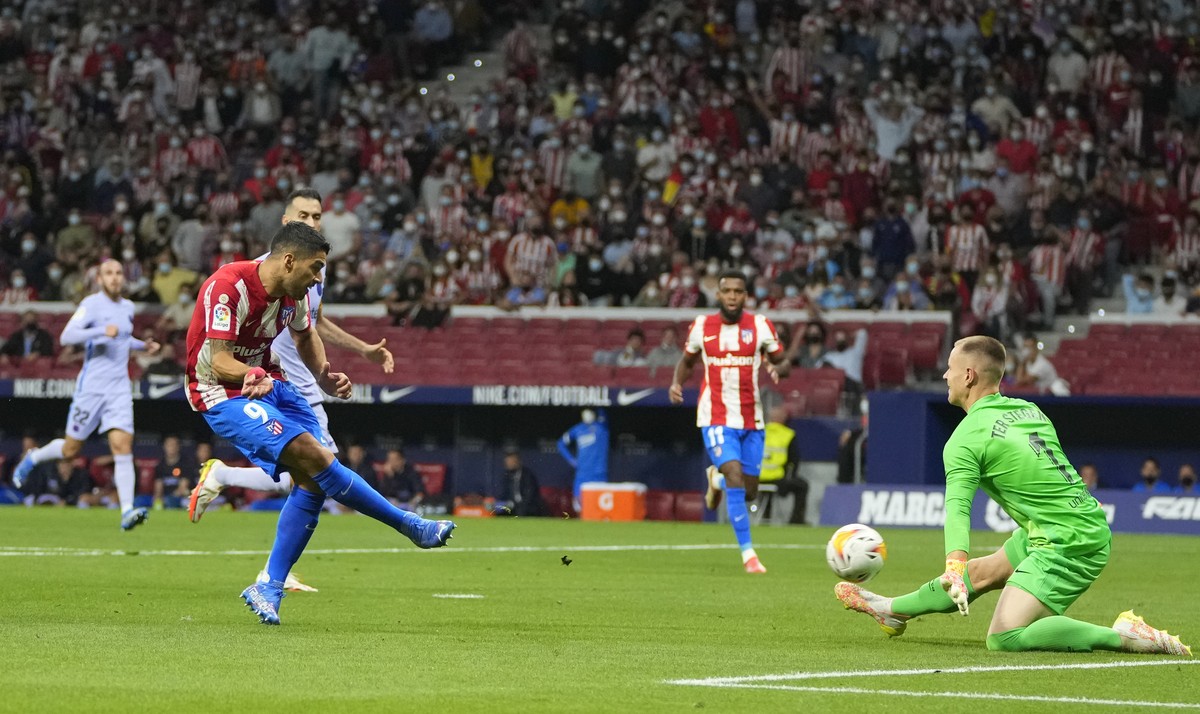 Atletico Madrid's Luis Suarez, left, scores his side's second goal during the La Liga soccer match between Atletico Madrid and Barcelona at the Estadio Wanda Metropolitano in Madrid, Saturda ...