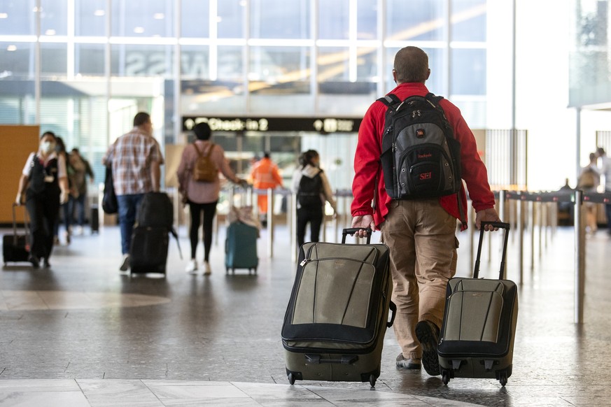 Menschen mit Reisegepaeck am Flughafen Zuerich, fotografiert am Donnerstag, 1. April 2021. (KEYSTONE/Alexandra Wey)