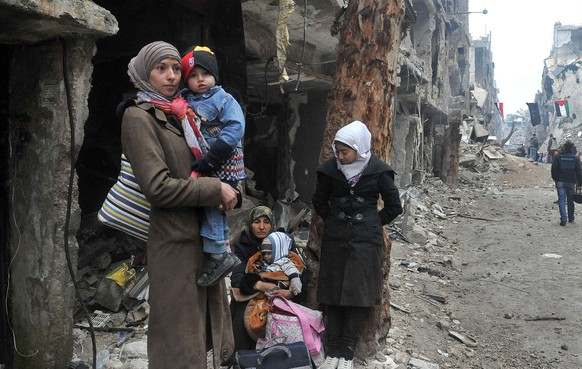 epa04055254 A handout photo released by Syria&#039;s official state news agency Syrian Arab News Agency (SANA) shows residents wait to be evacuated from al-Yarmouk refugee Palestinian camp in Damascus ...