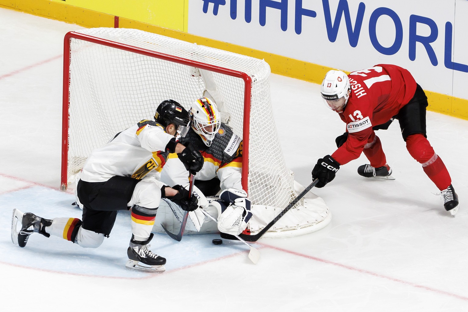 Switzerland&#039;s forward Nico Hischier #13 confronts Germany&#039;s goaltender Mathias Niederberger past Germany&#039;s defender Moritz Muller #91, during the IIHF 2023 World Championship quarter fi ...