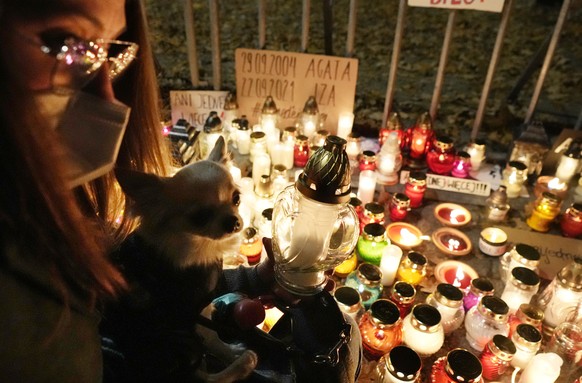 People place candles in tribute to a woman who died in the 22nd week of pregnancy, in Warsaw, Poland, Monday Nov. 1, 2021. Reproductive rights activists say the woman is the first person to die as a r ...