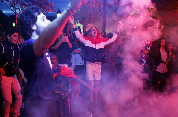 People celebrate on the Champs Elysees avenue after the semifinal match between France and Belgium at the 2018 soccer World Cup, Tuesday, July 10, 2018 in Paris. France advanced to the World Cup final ...