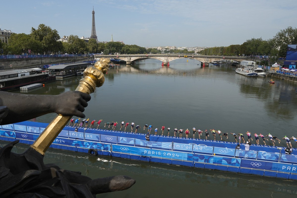 Athletes dive into the water for the start of the men's individual triathlon competition at the 2024 Summer Olympics, Wednesday, July 31, 2024, in Paris, France. (AP Photo/Vadim Ghirda)