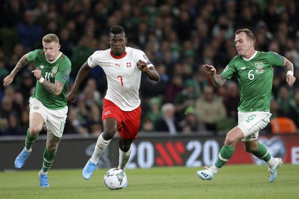 Switzerland&#039;s Breel Embolo runs with the ball between Ireland&#039;s James McClean and Glenn Whelan, right, during the Euro 2020 group D qualifying soccer match between Ireland and Switzerland at ...