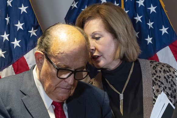 Former Mayor of New York Rudy Giuliani, left, listens to Sidney Powell, both lawyers for President Donald Trump, during a news conference at the Republican National Committee headquarters, Thursday No ...