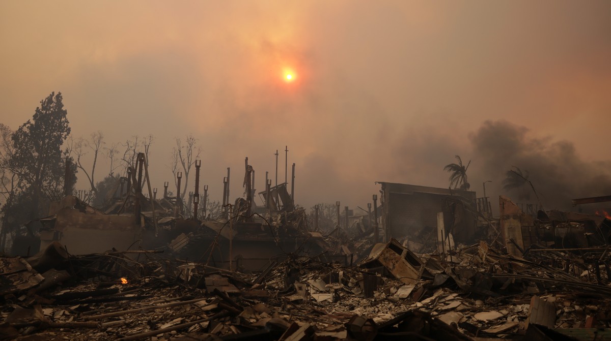epaselect epa11813904 The sun shines through smoke above ruins of homes from the Palisades wildfire in the Pacific Palisades neighborhood of Los Angeles, California, USA, 08 January 2025. According to ...