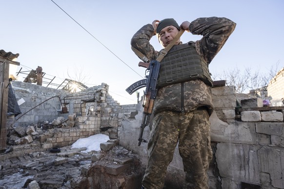 A Ukrainian soldier adjusts his gun near the ruined house at a line of separation from pro-Russian rebels, Donetskregion, Ukraine, Saturday, Jan. 8, 2022. President Joe Biden has warned Russia&#039;s  ...