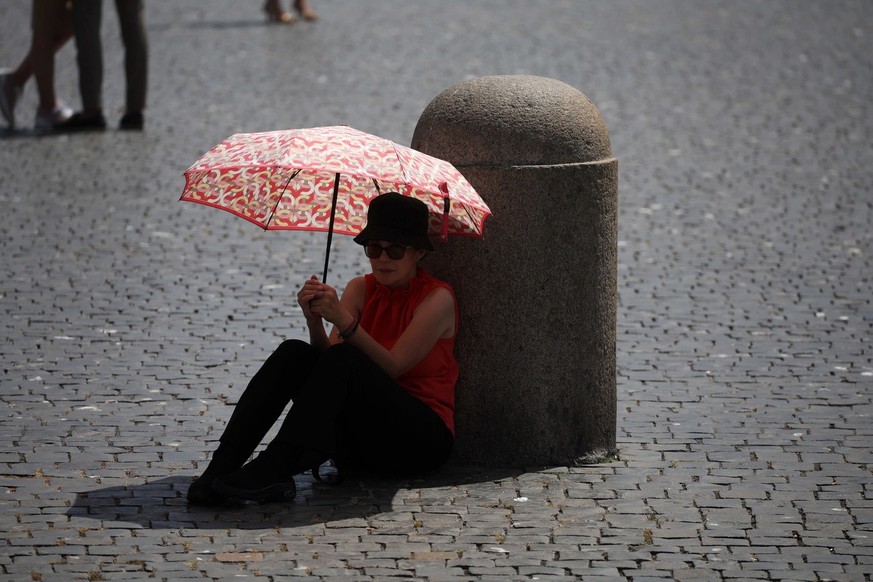 epa10749215 A woman protects herself from the sun with an umbrella in St. Peter&#039;s Square during Pope Francis&#039; Angelus prayer, Vatican City, 16 July 2023. EPA/MASSIMO PERCOSSI