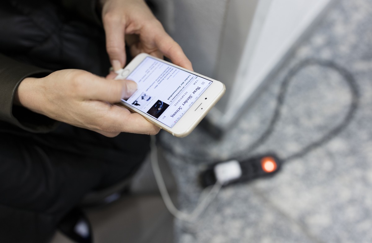 ARCHIV -- ZUM OPERATIVEN START DES JOINT VENTURES CH MEDIA AM MONTAG, 1. OKTOBER 2018, STELLEN WIR IHNEN FOLGENDES BILDMATERIAL ZUR VERFUEGUNG -- A woman charges her phone in public to read the NZZ ne ...