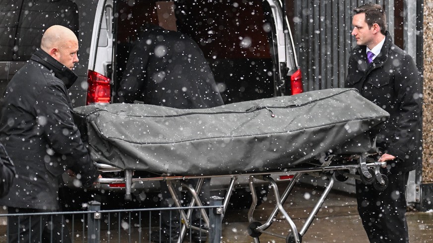epa10513234 Morticians handle a body on a stretcher at the scene of a shooting in Hamburg, Germany, 10 March 2023. According to police, at least eight people died, including the suspected gunman, and  ...