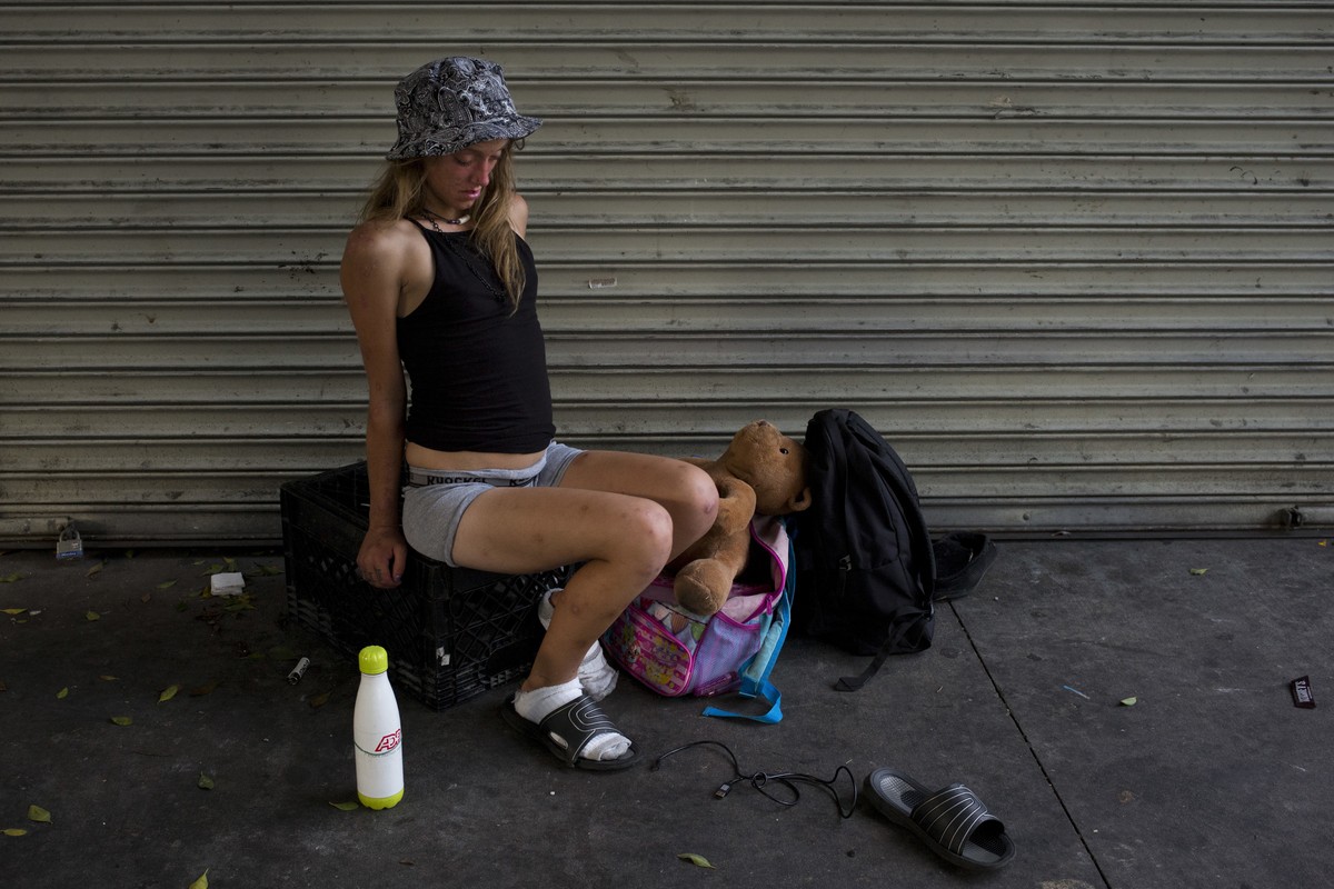 A young homeless woman, in a drug-induced state, wobbles while sitting on a milk case with a teddy bear in Los Angeles' Skid Row area, home to the nation's largest concentration of homeless  ...