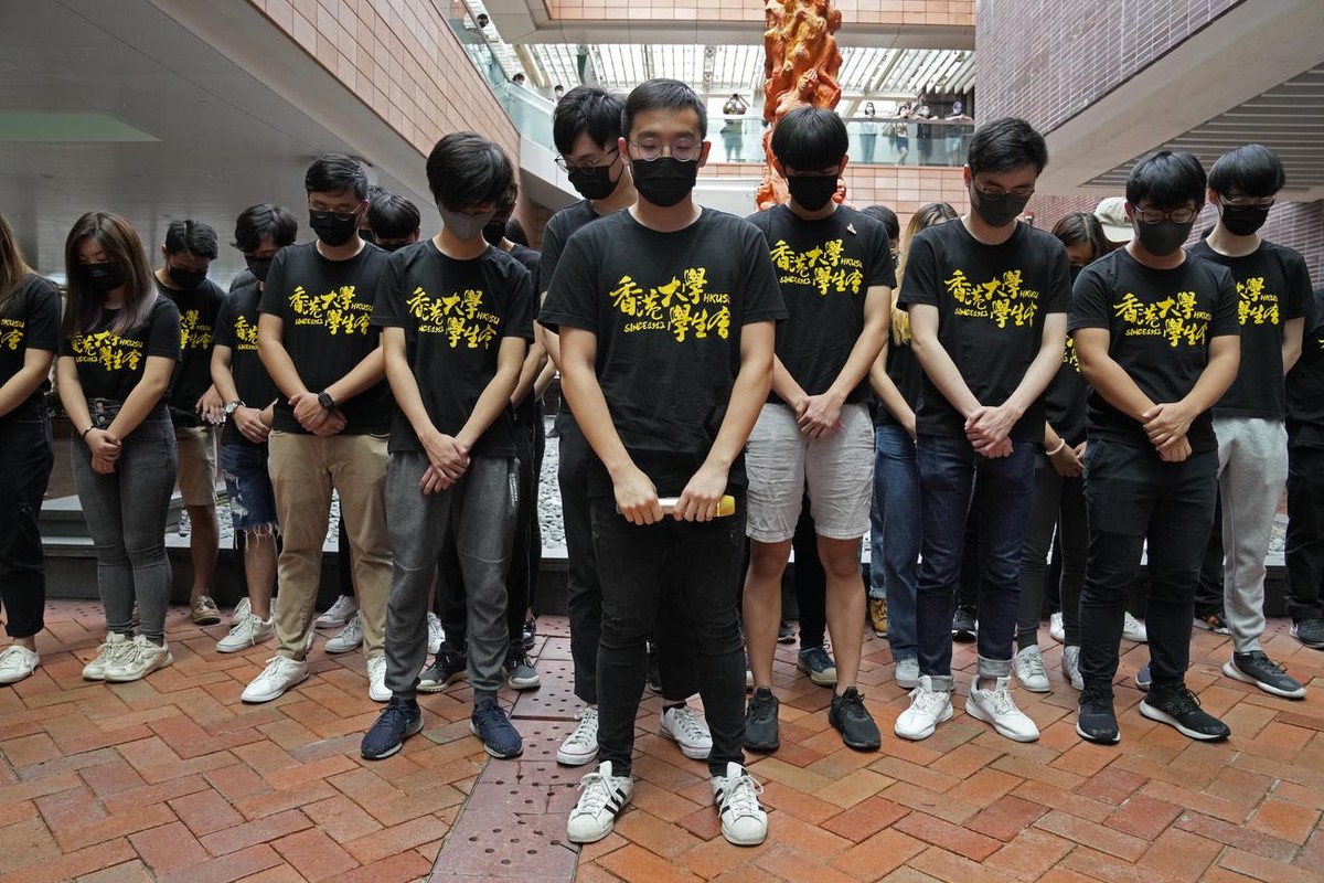 University students observe one minute silence to mourn those killed in the 1989 Tiananmen crackdown, in front of the "Pillar of Shame" statue at the University of Hong Kong, Friday, June 4, ...