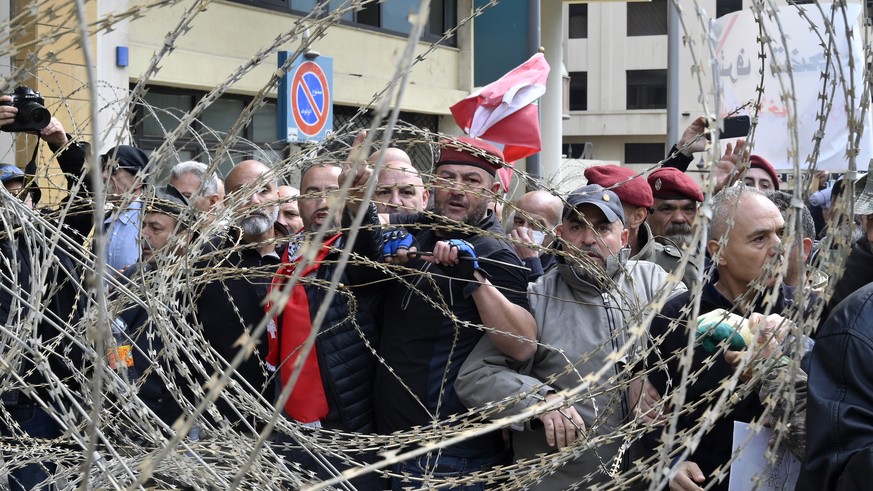 epa10550585 Retired members of Lebanese security try to remove barbed wire during a protest outside the government palace in downtown Beirut, Lebanon, 30 March 2023. Hundreds of retired members of the ...