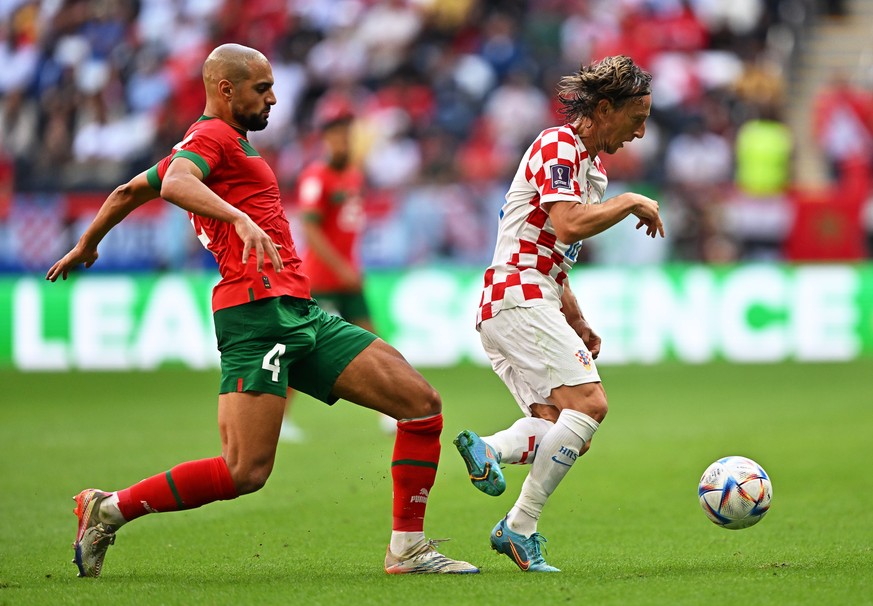 epa10322215 Sofyan Amrabat (L) of Morocco in action against Luka Modric (R) of Croatia during the FIFA World Cup 2022 group F soccer match between Morocco and Croatia at Al Bayt Stadium in Al Khor, Qa ...