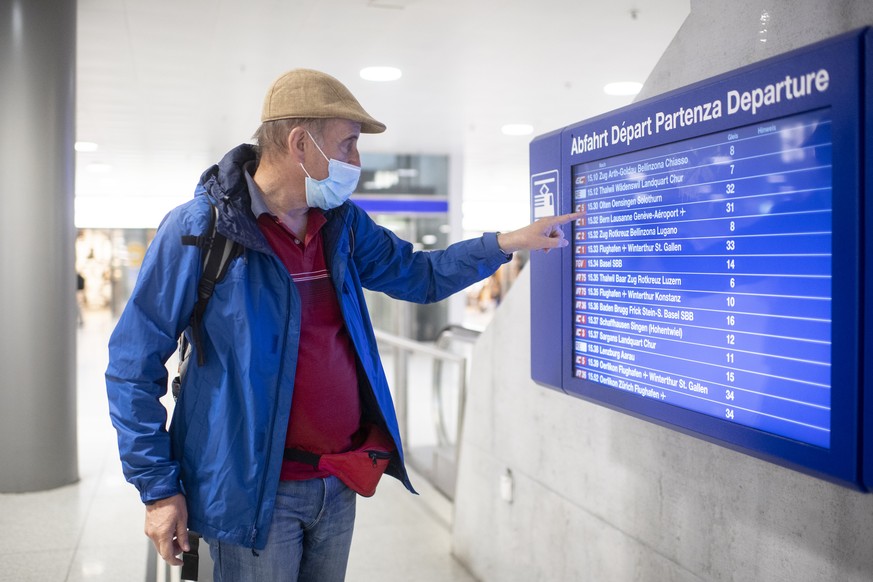 Ein Mann mit Atemschutzmaske sucht seinen Zug auf der Abfahrtstafel im Hauptbahnhof in Zuerich, aufgenommen am Freitag, 3. Juli 2020. (KEYSTONE/Ennio Leanza)