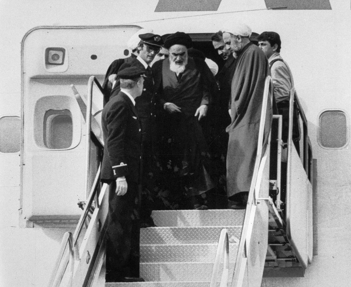 FILE - In this Feb. 1, 1979 file photo, Ayatollah Ruhollah Khomeini, Iran's exiled religious leader, emerges from a plane after his arrival at Mehrabad airport in Tehran, Iran. Friday, Feb. 1, 20 ...