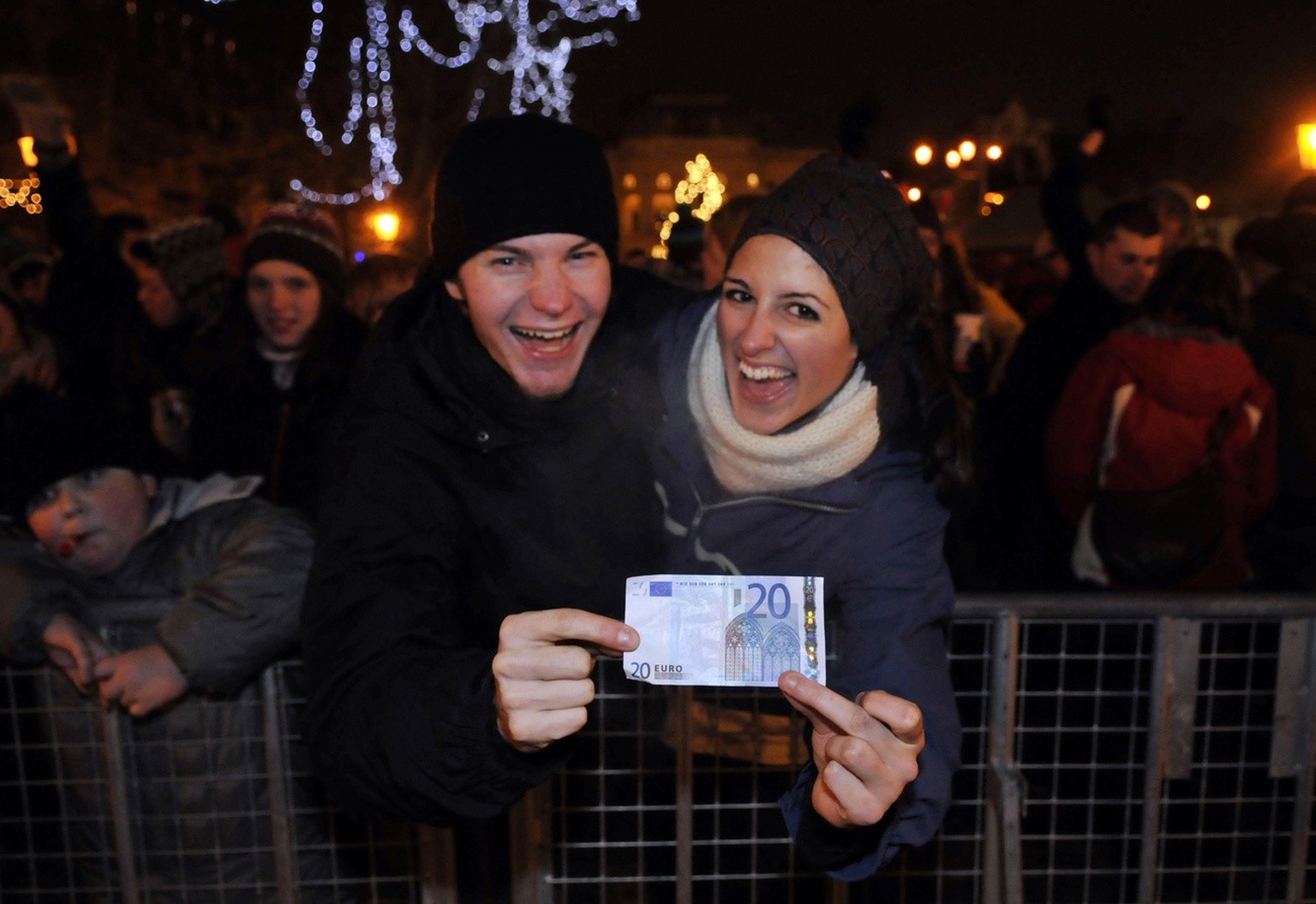 Two unidentified Slovak citizens hold a twenty-euro banknote during the New Year celebrations in Slovak capital Bratislava on Thursday, Jan. 1, 2009. Slovakia exchanged the crown national currency for ...