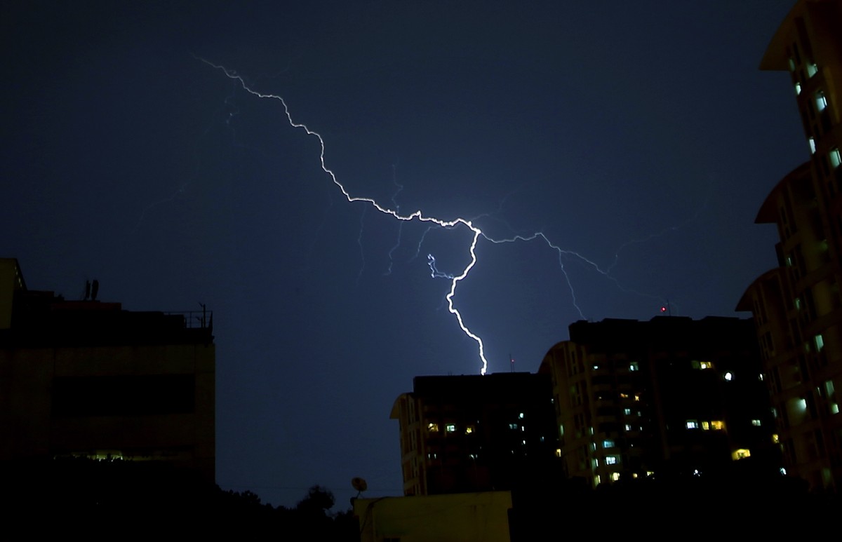 epa09919154 Image taken in a long exposure showing bolts of lightning above India's technology hub Bangalore during an evening thunder and rainstorm, in southern city of Bangalore, India, 30 Apri ...