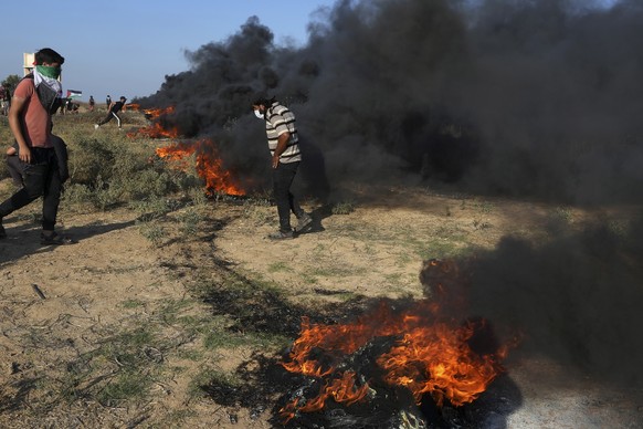 Palestinian protesters burn tires during clashes with Israeli security forces along the frontier with Israel, east of Gaza City, Friday, Sept. 22, 2023. The Israeli military said it struck three posts ...
