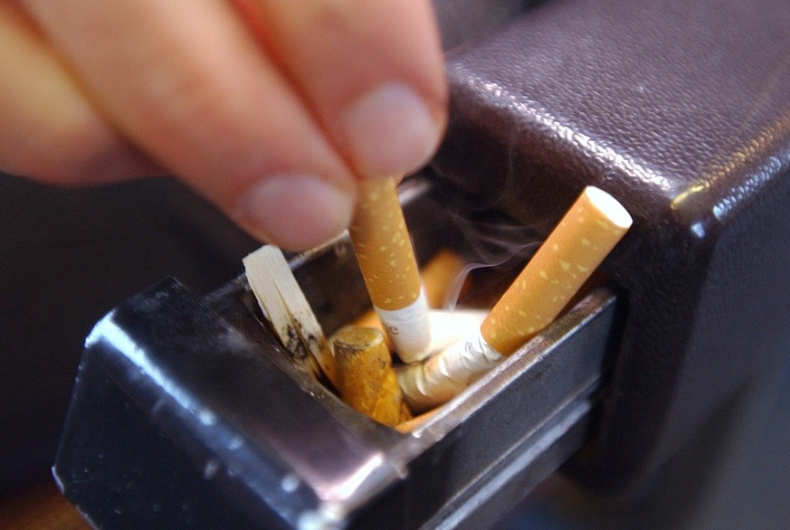 Ein Mann drueckt eine Zigarette im Aschenbecher aus, am Donnerstag, 8. Januar 2004 in einem Zug in Zuerich. Bald muss auf das Rauchen in den SBB Zuegen verzichtet werden, weil Raucherwagen und -abteil ...