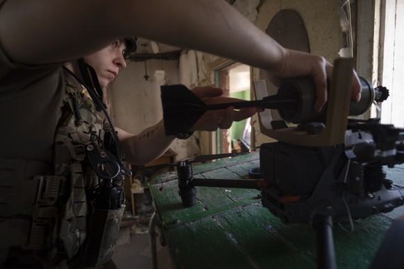 epa11599786 A soldier from the Ukrainian intelligence unit &#039;Ochi&#039; of the 120th Reconnaissance Regiment attaches an explosive shell to an attack drone in the town of Chasiv Yar, Donetsk regio ...